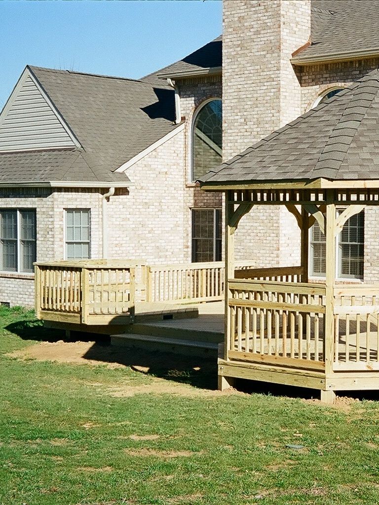 A beautiful wooden deck with a built-in bench, perfect for outdoor relaxation – designed by a Nashville deck builder.